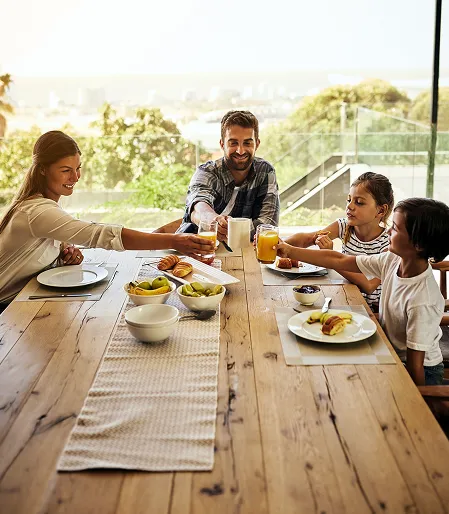 Familia feliz em uma mesa de madeira Pau Brasil